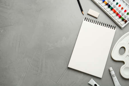 Flat lay composition with blank sketchbook on light gray stone table. Space for textの写真素材