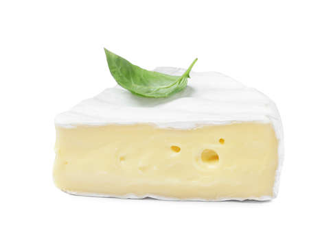 Piece of tasty brie cheese with basil isolated on whiteの写真素材