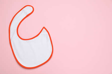 New baby bib on pink background, top view. Space for textの写真素材