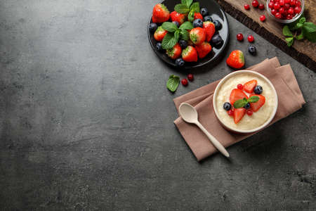Delicious semolina pudding with berries and mint served on gray table, flat lay. Space for textの写真素材