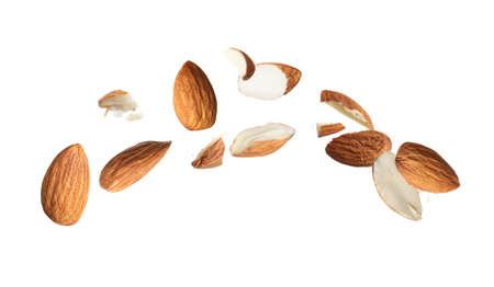 Pieces of tasty almonds falling on white backgroundの写真素材