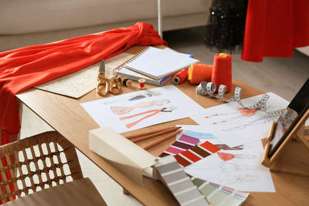 Sketches of fashion clothes and thread supplies at designer's workplace indoorsの写真素材