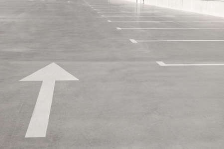 Outdoor car parking lot with arrow on sunny day
