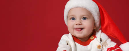 Cute baby wearing Santa hat on red background, banner design with space for text. Christmas...