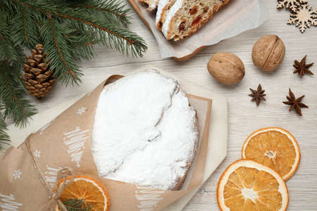 Wrapped Christmas Stollen with decoration on wooden table, flat layの写真素材