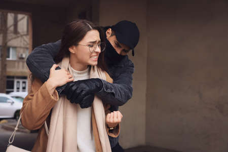 Woman defending herself from attacker in alley, space for textの写真素材