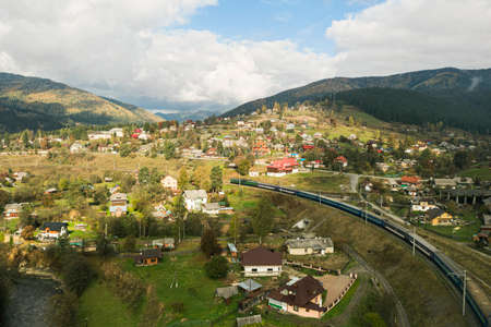 Aerial view of train on bridge and mountain villageの写真素材