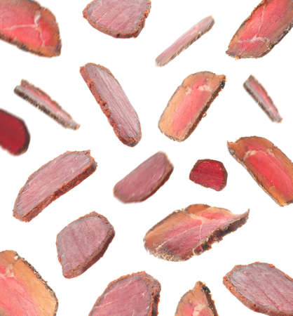 Slices of delicious dry-cured basturma falling on white backgroundの写真素材