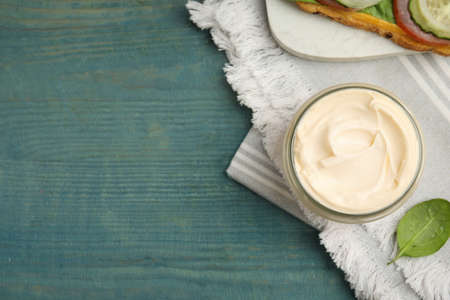 Jar of delicious mayonnaise on light blue wooden table, flat lay. Space for textの写真素材