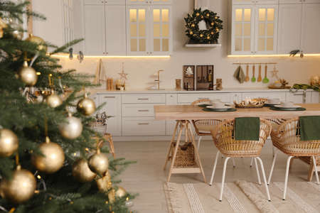Beautiful Christmas tree in spacious kitchen, closeup. Space for textの写真素材