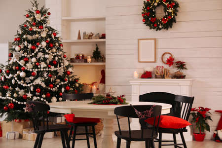 Cozy dining room interior with Christmas tree and festive decorの写真素材