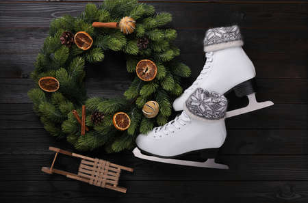 Pair of ice skates with Christmas decor on black wooden background, flat layの写真素材