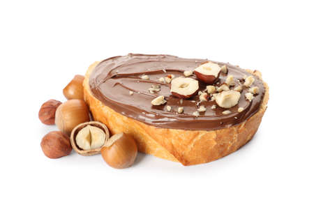 Bread with tasty chocolate spread and pieces of hazelnuts on white backgroundの写真素材