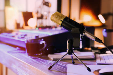 Microphone near professional mixing console on table in radio studioの写真素材