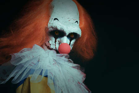 Terrifying clown on black background. Halloween party costumeの写真素材