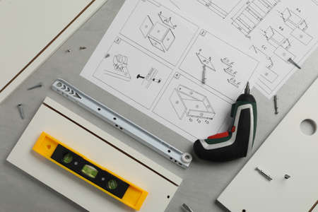 Flat lay composition with furniture parts and tools for self-assembly on gray backgroundの写真素材