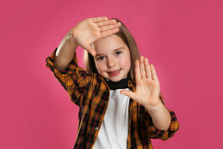 Cute little girl wearing stylish bandana on pink background