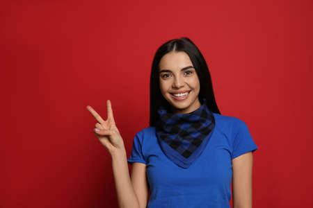 Young woman wearing stylish bandana on red background, space for textの写真素材