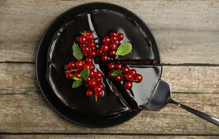 Tasty homemade chocolate cake with berries and mint on wooden table, top viewの写真素材