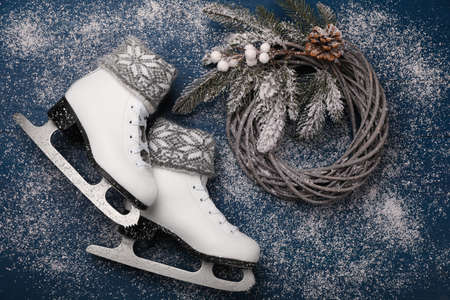 Pair of ice skates with Christmas decor on blue wooden background, flat layの写真素材