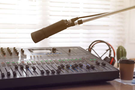 Microphone near professional mixing console in radio studio