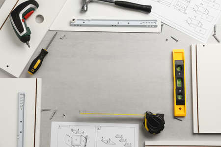 Frame of furniture assembly parts and tools on light gray background, flat lay. Space for textの写真素材