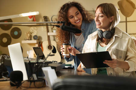 Young women working in modern radio studioの写真素材