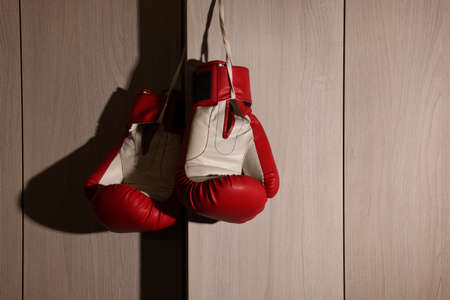 Red boxing gloves hanging on locker door in changing roomの写真素材