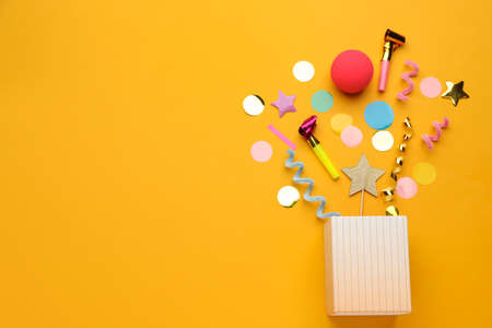 Flat lay composition with party items and box on orange background, space for textの写真素材