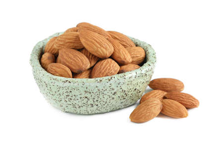 Bowl and organic almond nuts on white background. Healthy snackの写真素材
