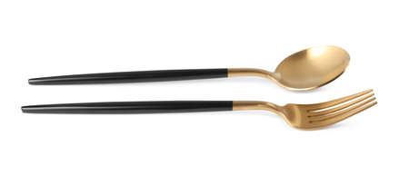 New golden fork and spoon with black handles on white backgroundの写真素材