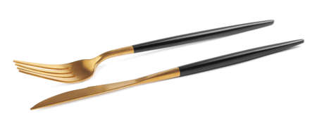 New golden fork and knife with black handles on white background