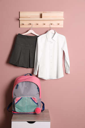 School uniform for girl and backpack near beige wallの写真素材