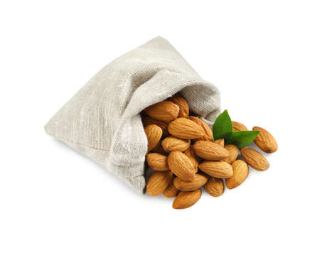 Sack with organic almond nuts and green leaves on white background. Healthy snackの写真素材