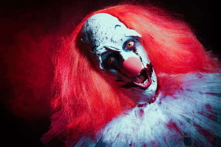 Terrifying clown on dark background. Halloween party costumeの写真素材