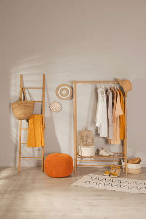 Modern dressing room interior with stylish clothes, shoes and orange poufの写真素材