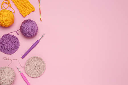 Flat lay composition with knitting threads and crochet hooks on pink background, space for textの写真素材