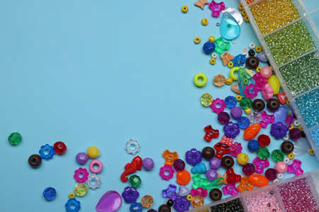 Flat lay composition with different colorful beads on light blue background, space for textの写真素材
