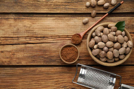Ground nutmeg and whole seeds on wooden table, flat lay. Space for textの写真素材
