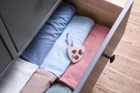 Beautiful heart shaped scented wax sachet and clothes in dresser drawer indoors, closeupの写真素材