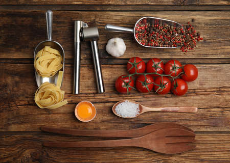Cooking utensils and ingredients on wooden table, flat layの写真素材