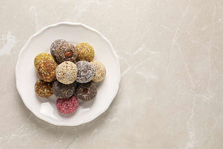 Different delicious vegan candy balls on light gray marble table, top view. Space for textの写真素材