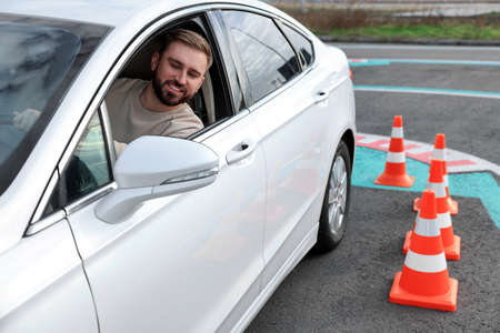 Young man in car on test track with traffic cones. Driving schoolの写真素材