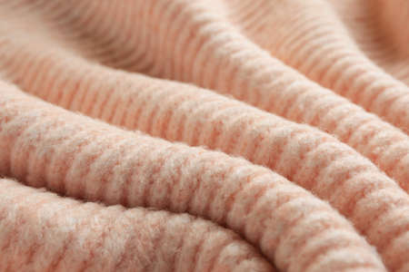 Beautiful pale pink knitted fabric as background, closeup