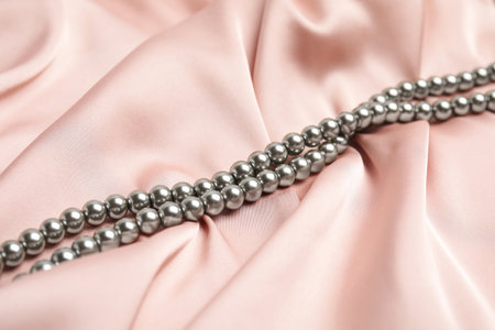 Beautiful silver pearls on delicate pink silkの写真素材