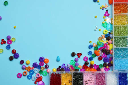 Flat lay composition with different colorful beads on light blue background, space for textの写真素材