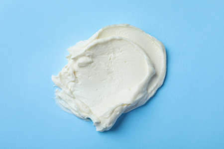 Smear of delicious cream cheese on light blue background, top viewの写真素材