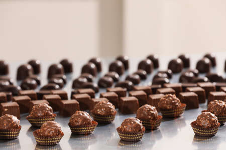 Many delicious chocolate candies on gray table. production lineの写真素材