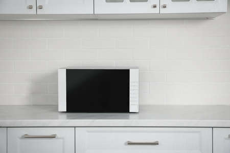 Modern microwave oven on countertop in kitchenの写真素材