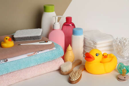 Towels, toys and baby accessories on white table